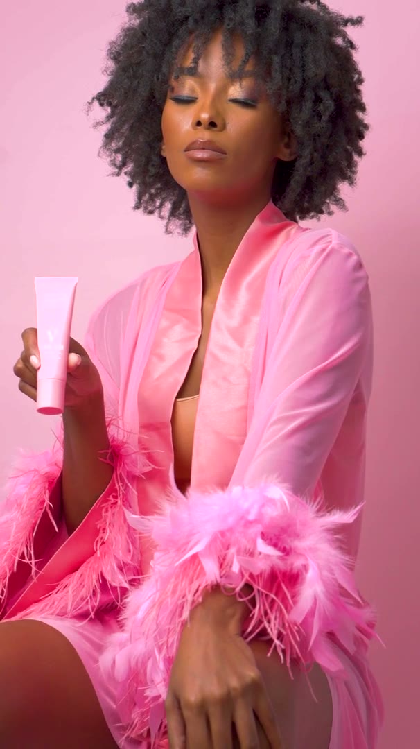 Model holding a pink Skinstem tube in a pink robe